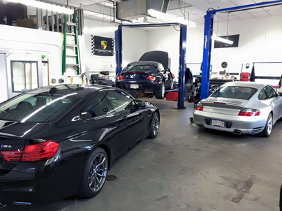 BMW M4, Z4 and a Porsche Carrera in the garage.